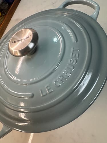Customer's close-up of their light blue Le Creuset Round French Oven, focusing on the glossy lid and silver knob.
