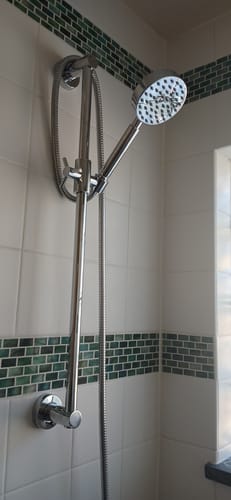 Customer's installed chrome Slide Bar with Handheld Shower Head on a tiled shower wall.