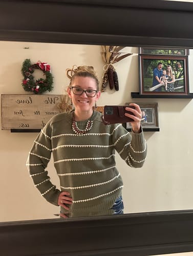 Reviewer taking a mirror selfie in the green Stitched Stripes Accented Sweater.