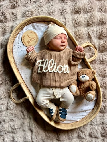 A reviewer's baby wearing the brown Hand Knitted Personalized Sweater with the name 'Elliot' on it.