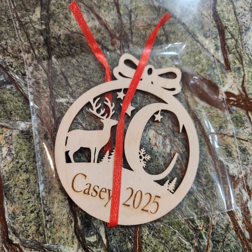 Customer's personalized wooden deer ornament showing the name 'Casey', the initial 'C', and the year '2025'.