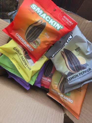 Customer's delivery box filled with multiple colorful bags of Smackin' flavored sunflower seeds.