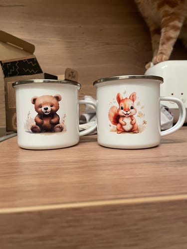 Kundenbild von zwei schönen Emaille-Tassen für Kinder, eine mit einem Bären und eine mit einem Eichhörnchen.