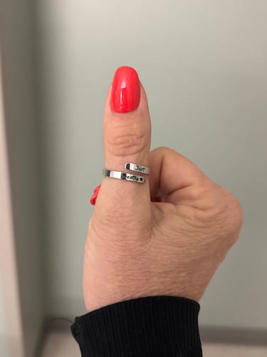 Close-up of a reviewer wearing the silver Just Breathe Ring on their thumb, showing the engraving.