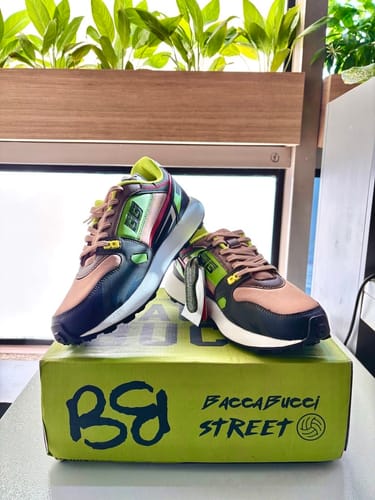 Customer's colorful Bacca Bucci TORQUE sneakers displayed on top of the matching green product box.