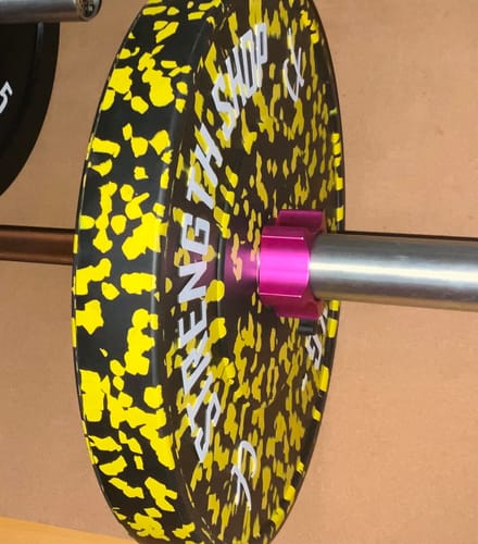 Customer's black Fleck Rubber Bumper Plate with yellow flecks loaded onto a barbell.