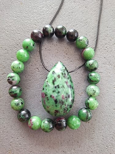 Photo d'un client du Pendentif Rubis Zoïsite en forme de goutte, posé au centre d'un cercle de perles assorties.