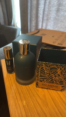 Customer's Ko Meme perfume bottle and beautiful box displayed on a wooden table.