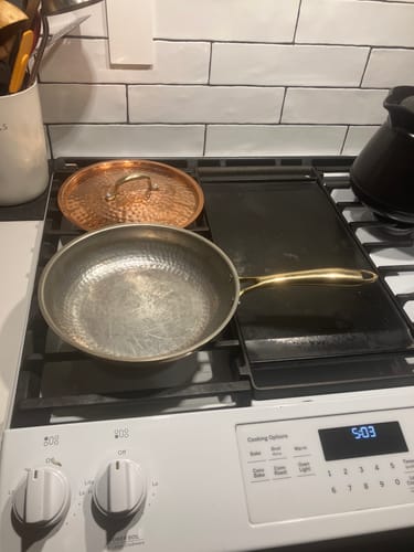 Customer's new Nutri Pan Pro 2.0 and its hammered copper lid resting on a white stovetop.