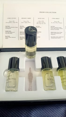 Customer's Asēdos Perfume Oil Collection in its gift box, showing a stain in the packaging from a leaking bottle.