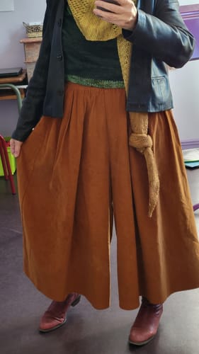 Cliente portant le Pantalon Paco ample en velours écureuil, associé à une veste noire.