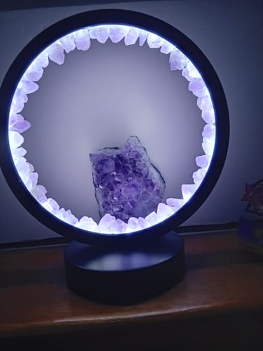 Photo d'une cliente de la Lampe de Protection Spirituelle allumée, posée sur un meuble en bois.