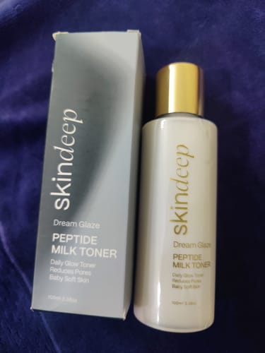 Customer's skindeep Dream Glaze Peptide Milk Toner bottle next to its grey and white packaging box.
