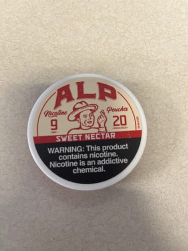 Customer's photo of a white can of ALP Sweet Nectar Nicotine Pouches on a plain surface.