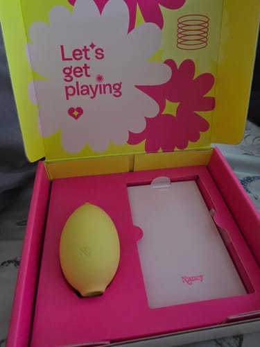 Customer showing the yellow Lem Clitoral Massager in its vibrant pink and yellow packaging.