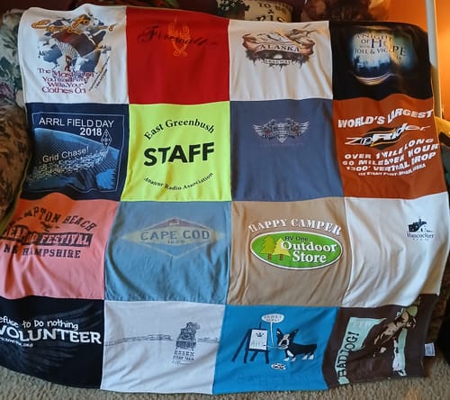 Customer's colorful Premium T Shirt Quilt, featuring a grid of t-shirts with travel and activity logos.