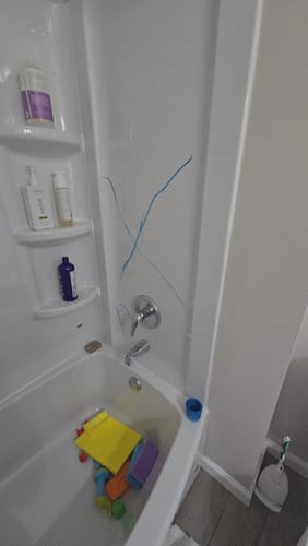 Customer's shower wall with blue crayon marks before using Bathroom Concentrate 4x.