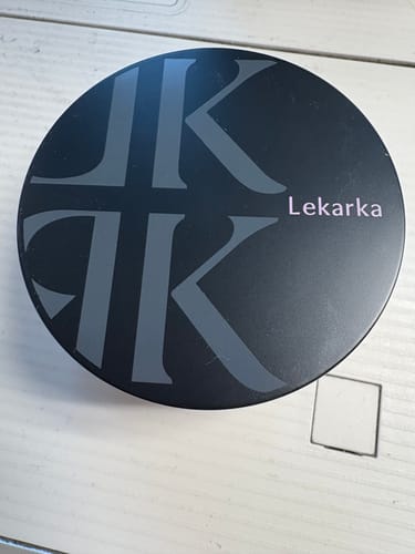 レビュー投稿者が撮影したイルミネイトパウダー。黒い円形の容器がテーブルに置かれている。