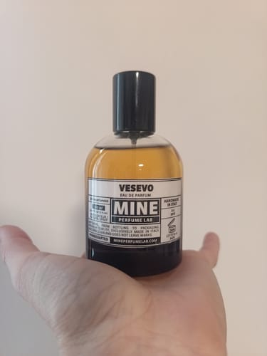 Cliente che tiene in mano il flacone di profumo Vesevo dal liquido ambrato.