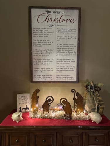 Customer's Christmas Story Sign III displayed on a wall above a nativity scene on a console table.