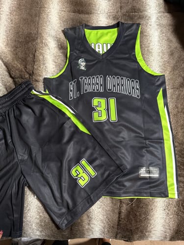 Customer's custom black basketball jersey and shorts with neon green lettering and side stripes laid out.