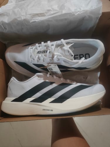 Customer's new white Adizero EVO SL Running Shoes with black stripes, displayed in the open shoebox.
