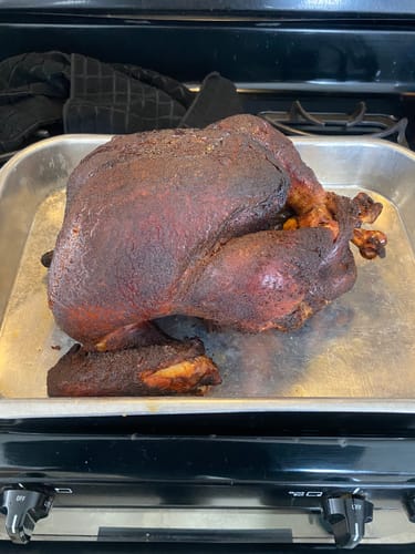 Customer's dark, roasted turkey in a metal pan on a stovetop, prepared using the Turkey Brine Kit.