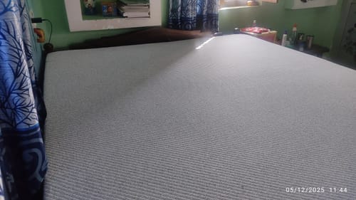 Customer's partial view of the Flo Anti-Gravity™ Latex Mattress showing its grey textured cover.