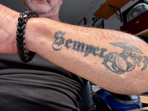 Customer wearing the Black Mamba Bracelet on their arm next to a Marine Corps tattoo.
