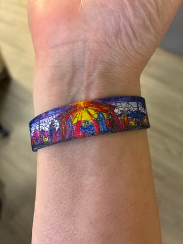 Customer's wrist wearing the Wonderfully Made Bible Verse Bracelet, showing the colorful stained-glass style nativity scene design.