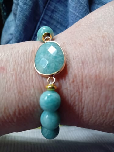 Une cliente porte le bracelet Amazonite, avec sa pierre centrale facettée, à son poignet.