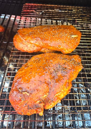 Reviewer's two seasoned turkey breasts on a smoker grill after using the Turkey Brine Kit.