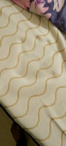 Close-up of a customer's Flo Mattress Ergo, showing the textured white cover with a tan wavy pattern.