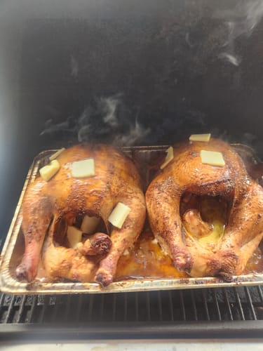Customer's two golden-brown turkeys smoking in a pan, prepared using the Turkey Brine Kit.
