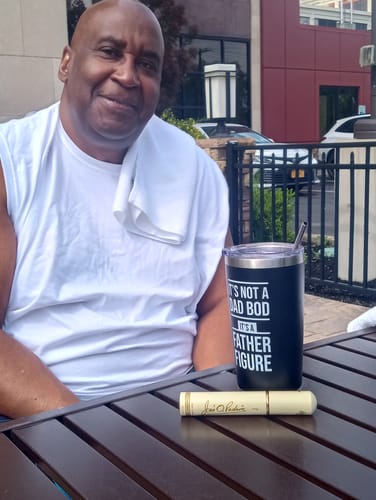 Customer photo for CREATE YOUR MELODY showing a smiling man seated at an outdoor table.