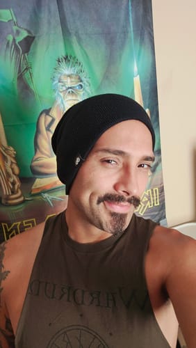 Reviewer smiling while wearing the black Leviathan Beanie unfolded.