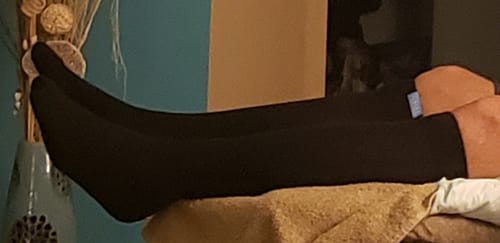 Reviewer relaxing with their feet up, wearing the black Performance Eucalyptus Compression Socks.