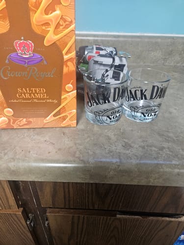 Customer's box of Crown Royal Salted Caramel whiskey sitting on a counter next to two whiskey glasses.