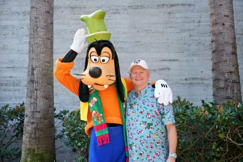 Customer wearing the Disney "Past & Presents" shirt, posing outdoors with the Goofy character.