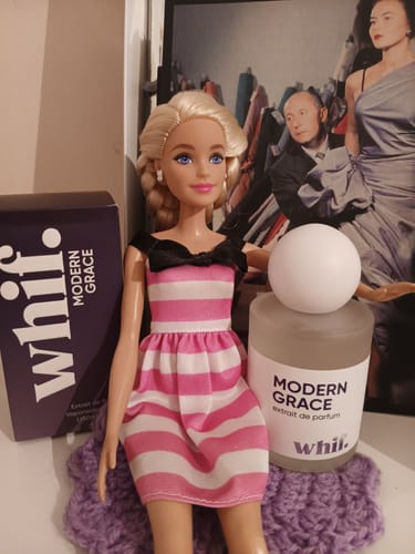 Customer's Modern Grace perfume bottle and box displayed next to a doll in a pink striped dress.