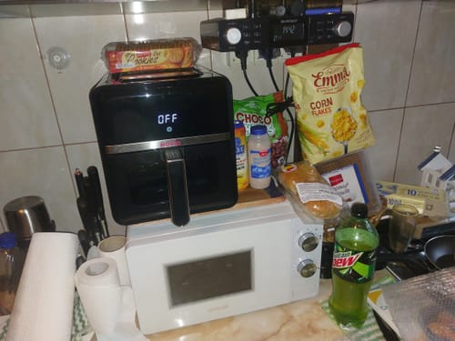 Clientul prezintă friteuza Air Fryer Novio StonePro, de culoare neagră, așezată pe un blat de bucătărie.