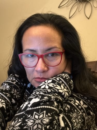 Reviewer shows the results after using the black hair dye, with her dark hair covering any grays.