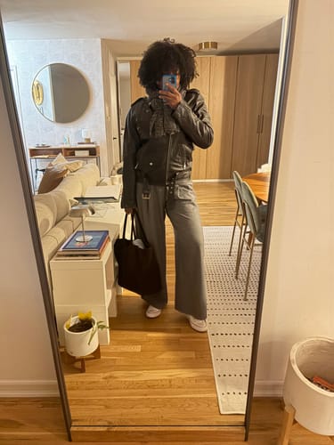 Reviewer's mirror selfie showing the fit of the grey Straight Leg Pants, styled with a jacket and sneakers.