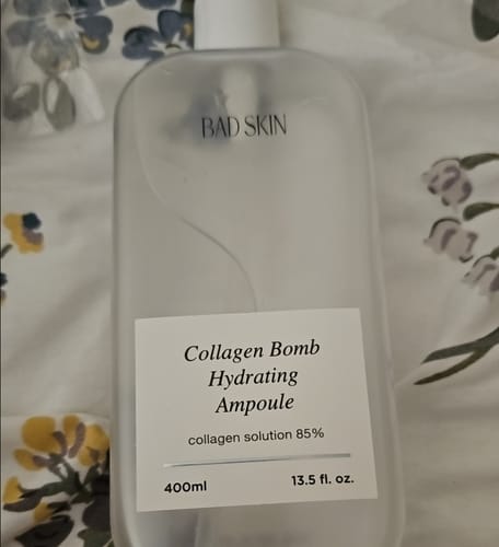 Reviewer's large, translucent bottle of Bad Skin Collagen Bomb Hydrating Ampoule.