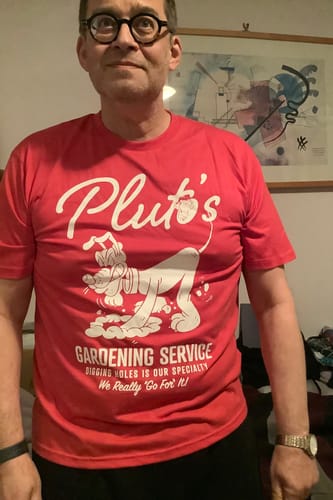 Reviewer wearing the bright red Pluto's Gardening Service crewneck tee.