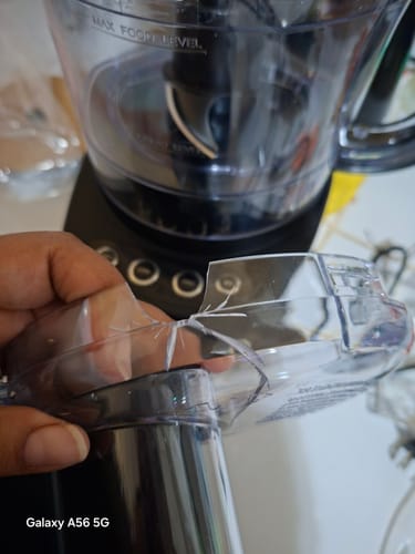 Un cliente muestra un primer plano de la tapa rota de su procesador de alimentos Black+Decker.