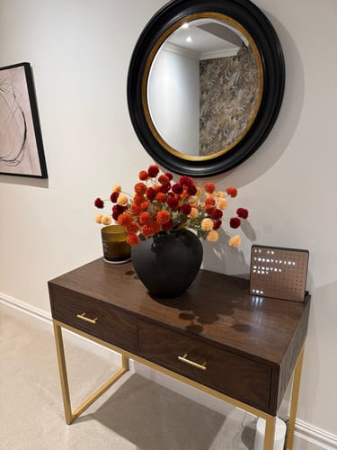 Customer's Faux Kiku Arrangement in assorted autumnal colors, displayed in a black vase on a console table.