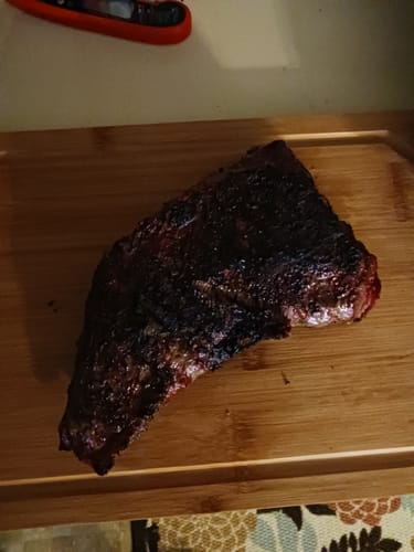 Reviewer's cooked USDA Choice Tri-tip with a dark crust, resting on a wooden cutting board.