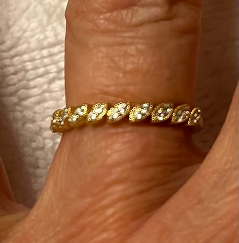 Customer wearing the subtle, gold-tone Tori Ring on their finger, showing the sparkling crystal details.