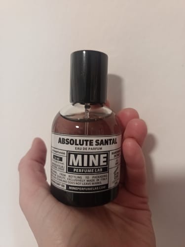 Recensore tiene in mano la boccetta di profumo Absolute Santal.